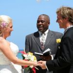 couple renewing vows in outdoor ceremony at the beach