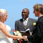 couple renewing vows in outdoor ceremony at the beach