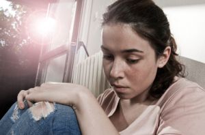 depressed female abuse victim sitting on porch