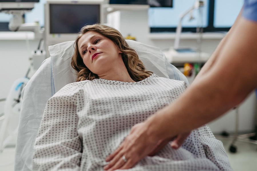 woman laying in hospital bed at abortion clinic