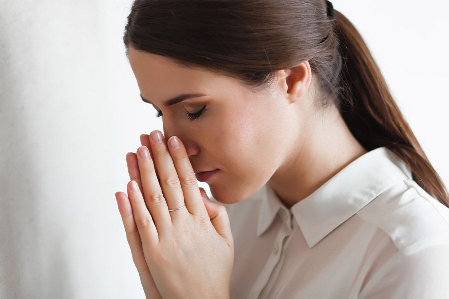 Woman's head bowed in prayer