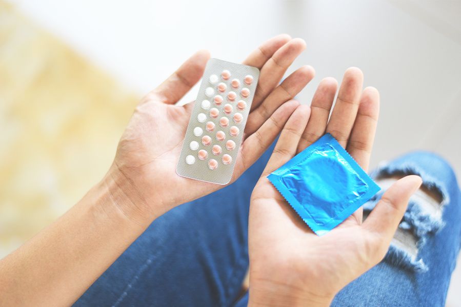 woman holding abortion pills and condoms