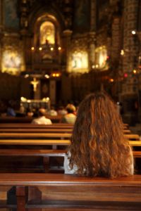 Woman sitting in church pews