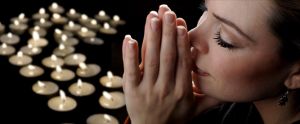 woman close-up with tea lights floating in the background