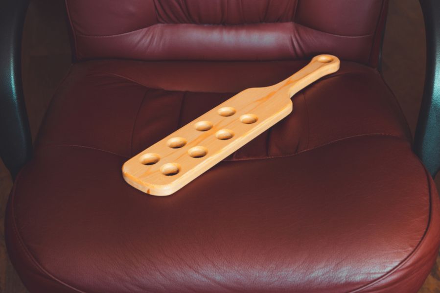 A wooden paddle on a chair
