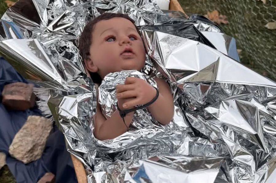 nativity scene with sign reading 'ICE was here' in place of jesus