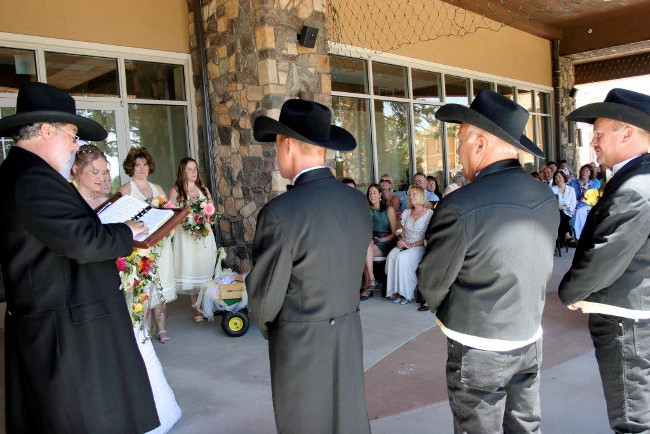 The wedding goers look on as this Wild West themed wedding commences.