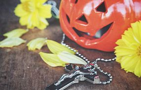 Christian cross on table with pumpkin jack o lantern