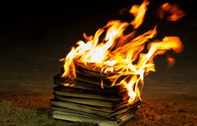 pile of religious books on fire