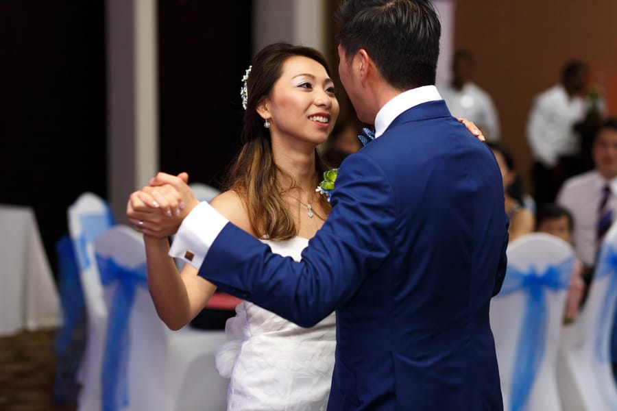 Smiling bride hudding groom after getting married at Buddhist wedding ceremony