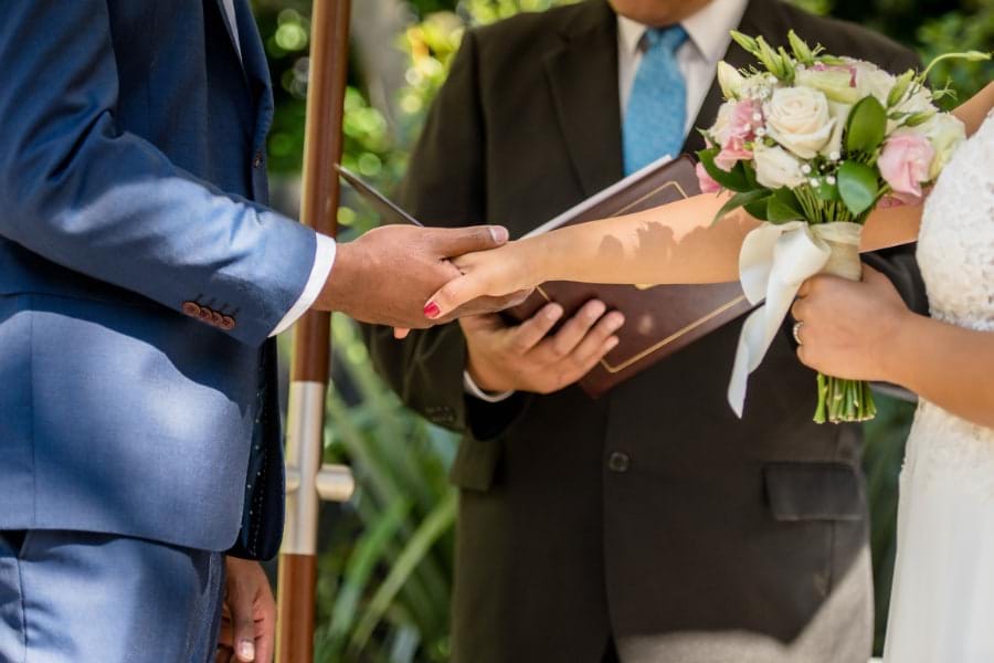 Bride and groom holding hands at wedding altar during fun wedding ceremony