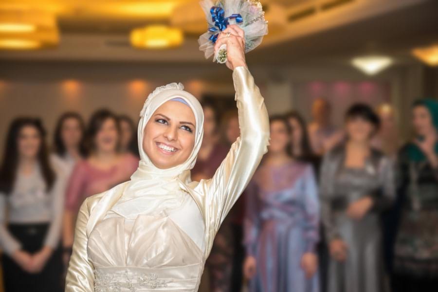 Muslim bride tossing bouquet over her shoulder