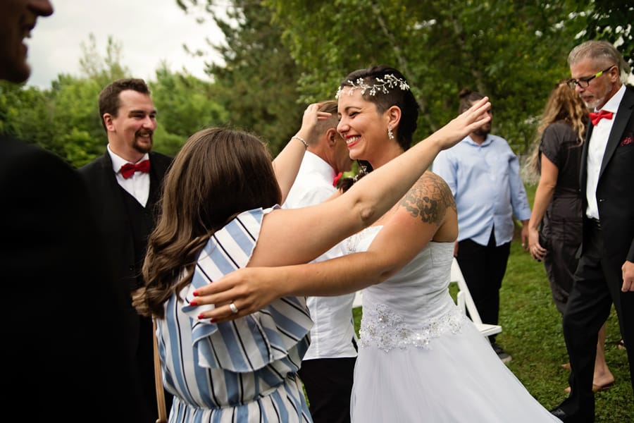 Short haired bride hugging bridesmaid on her wedding day