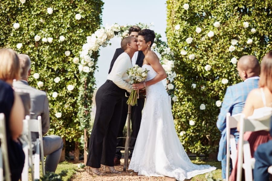 Brides sharing kiss during standard wedding ceremony