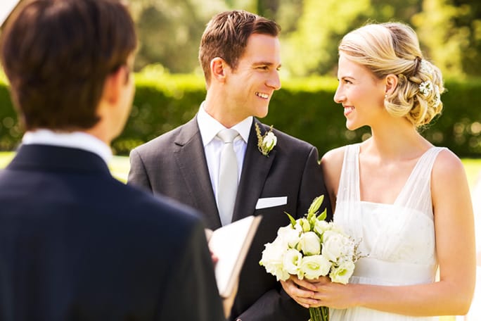 A beautiful couple getting married by a minister