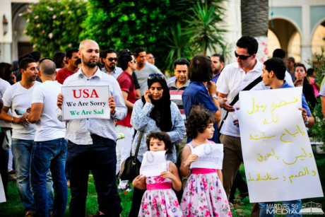 Libyan holding sign that says - USA, We are Sorry, We are Sad