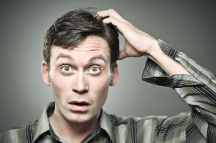A confused man scratching his head