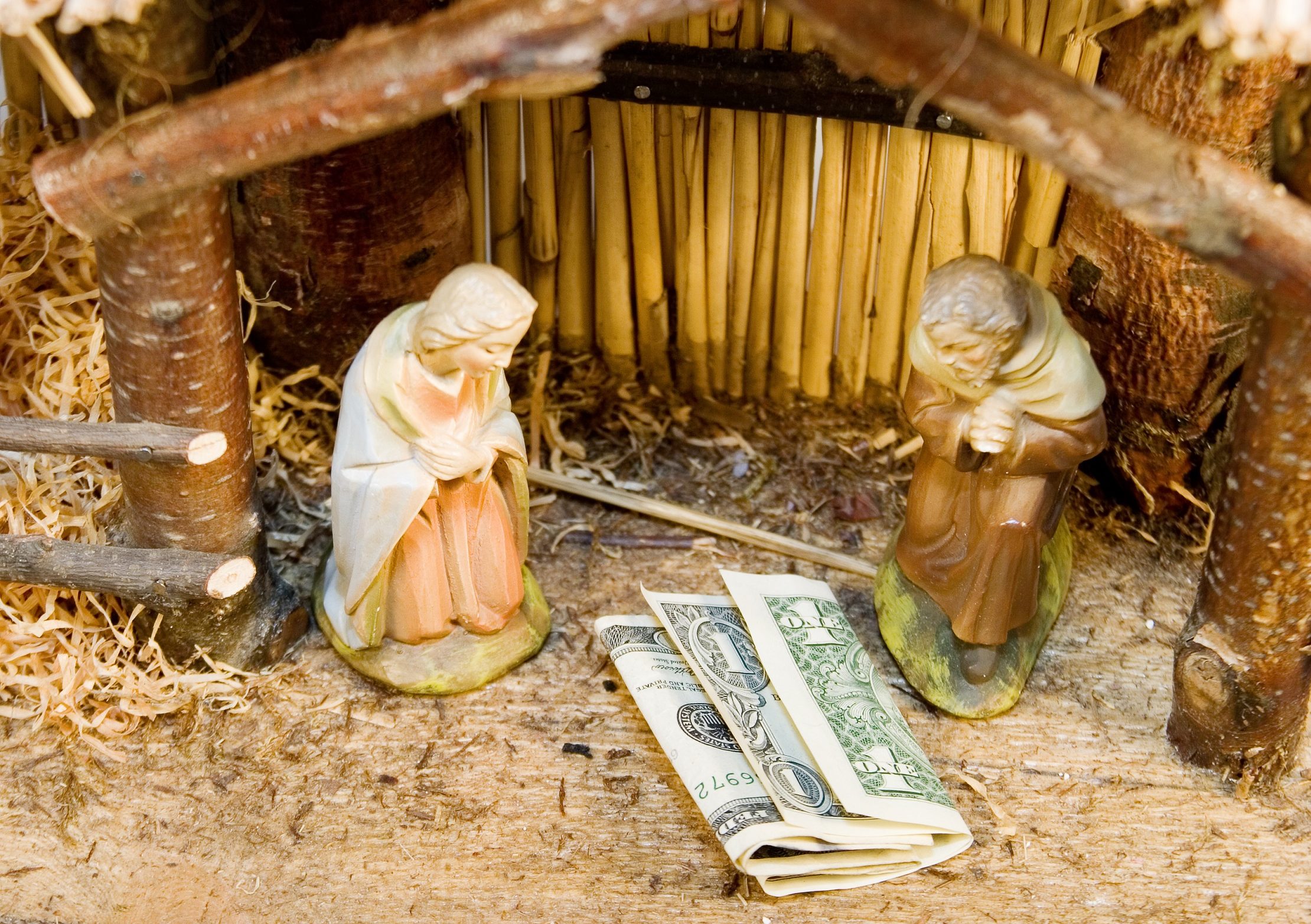 Money in a manger in place of Jesus Christ